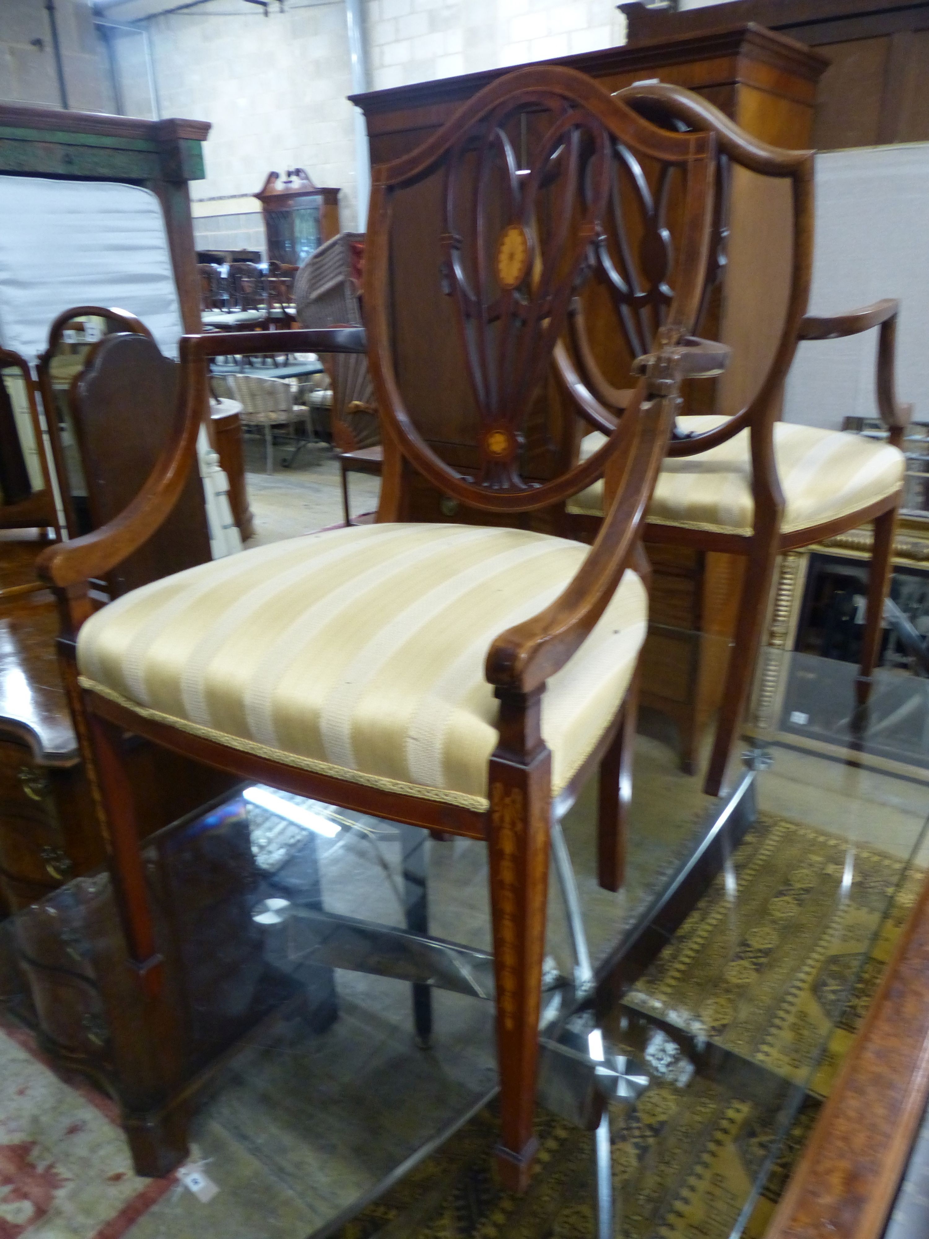 A pair of Edwardian Sheraton revival inlaid mahogany shield back elbow chairs (one a.f.)